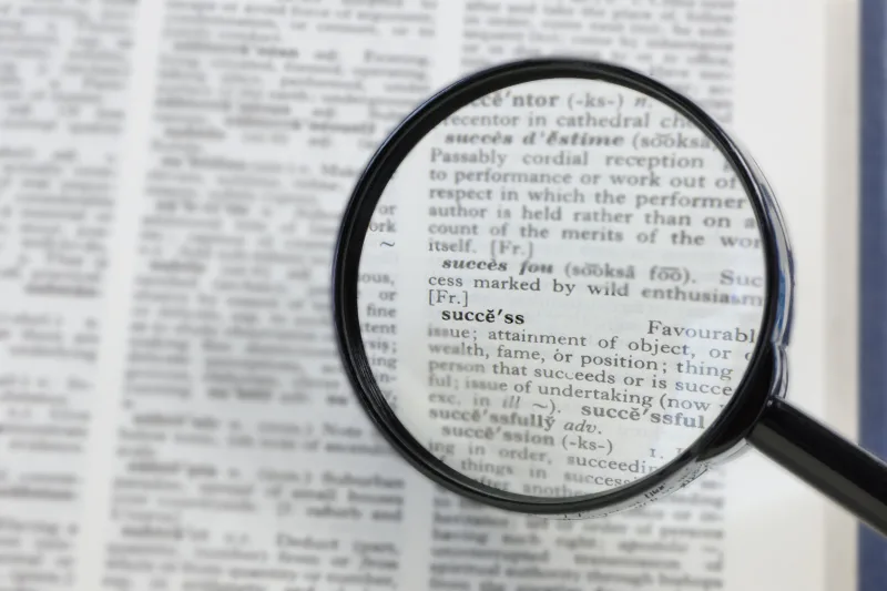 The word success in a dictionary, seen through a magnifying glass